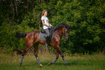 A girl rider trains riding a horse on a spring day.
