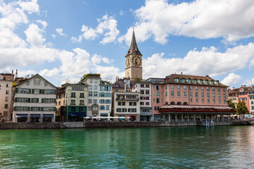 Fototapeta na wymiar Clock tower of St. Peter's Church, view the banks of the Limmat River. Zurich, Switzerland.