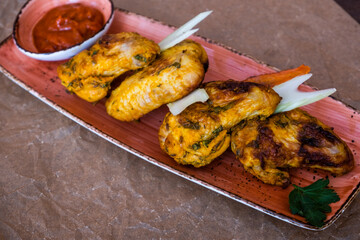 Photo of grilled chicken wings with barbecue sauce. Spicy chicken with sauce. Chicken meat on a plate.