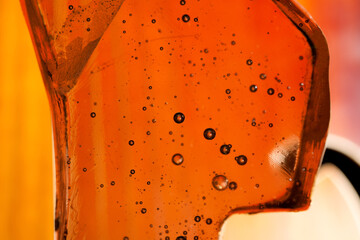 Fragment of transparent glass on a blurred background.