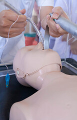 Closeup of hands demonstrate process of endotracheal tube intubation to manikin doll via plastic box. Respiratory failure, hypoxia, coronavirus infection concept.
Blue tone image. Selective focus