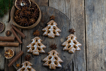 Christmas tree cookies on wooden background. New Year's food. Anise star. Festive baked goods. Gingerbread on the table.Icing sugar sweetness taste season