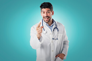 Male doctor pointing his finger to you while standing at isolated background