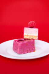 Mousse cake with raspberries on a red background.