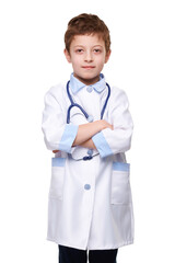 Fototapeta premium Boy doctor in medical gown with stethoscope folded his arms on chest on white isolated background