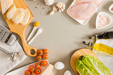 Caesar Salad Recipe. A set of products for the judgment of a delicious salad, in the center of the table is a white plate on which you can write a recipe for the dish. Romaine, chicken breast