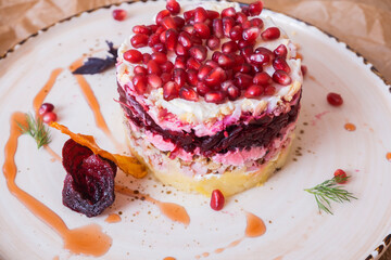 Photo of herring salad under a fur coat. Fish salad in a plate. Restaurant menu. Beautiful salad serving in a restaurant.