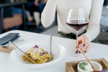 Holding glass with red wine at dinner table