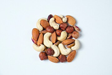 Pile of mixed nuts and dried berries isolated on white background. Healthy high-calorie vegan food concept. Close up, copy space, top view, flat lay.