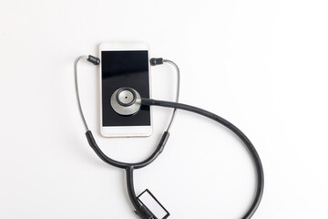 Smartphone and stethoscope on white background. Online medicine (telemedicine) technology. Service for remote diagnostic, chat with doctor.