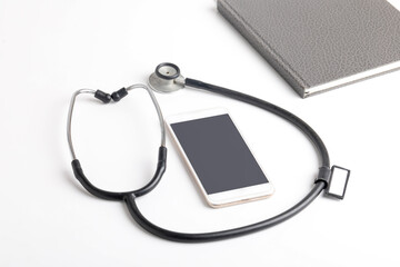 Smartphone and stethoscope on white background. Online medicine (telemedicine) technology. Service for remote diagnostic, chat with doctor.