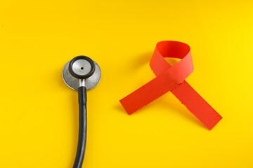 A heart with a stethoscope on yellow background.