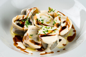 italian ravioli filled with ricotta cheese smothered in a creamy sauce on a dark background