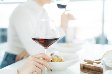 Person holding a glass of red wine