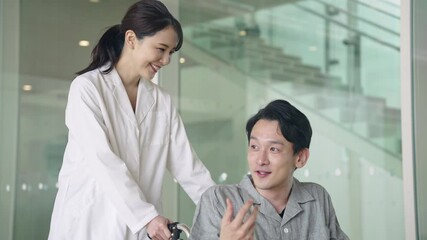 車椅子に乗った患者を励ます医師