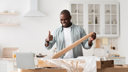 Happy black blogger gesturing thumb up, making table while shooting video instructions for...