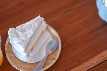 Fototapeta na wymiar Coconut cake is placed on the wooden table in the cafe.