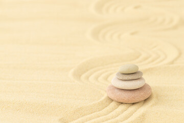 Sea pebbles stacked on top of each other on the sand - a summer backdrop for relaxation	
