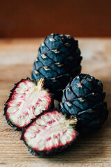 Zirbenzapfen auf Holzbrett teilweise geschnitten für Zirbenschnaps