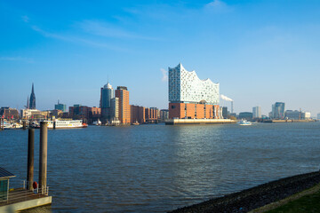 Concert hall Hamburger Elbphilharmonie along the river Elbe in daylight with a clear blue sky,...