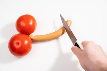 tomatoes and sausage in form of penis on white background. humor. Circumcision is removal of foreskin from boys for various purposes: social, religious, medical, national.