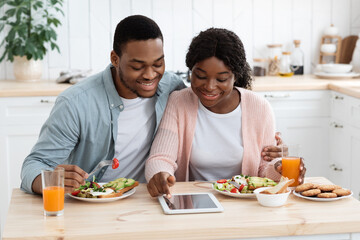 Obraz na płótnie Canvas Young Black Millennial Spouses Shopping Online On Digital Tablet While Having Breakfast