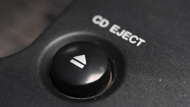Close-up of a man's finger presses the mechanical button for ejecting a cd disc from a retro turntable