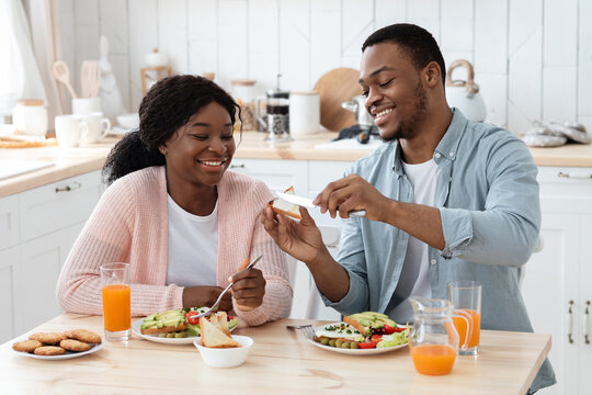 Happy Black Man Spreading Butter To Toast While Having Breakfast With Wife