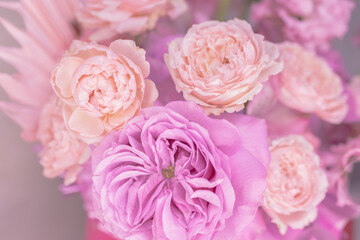 Fototapeta na wymiar Light pink, purple, peach colour, white cute delicate small roses of different sizes, flowers in a lush bouquet. Close-up