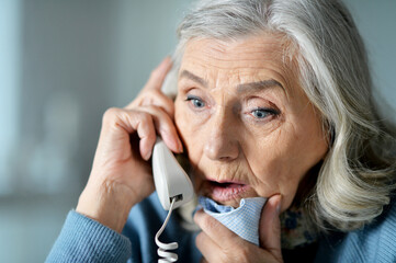 Portrait of upset senior woman calling doctor