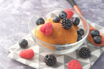 Tasty meal with berries and pan cake in bowl on black background