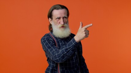 Senior old bearded gray-haired man pointing around with finger gun gesture, looking confident, making choice, shooting killing with hand pistol right on target. Elderly mature grandfather pensioner
