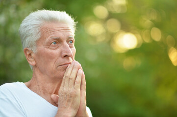 portrait of senior man  in  park praying