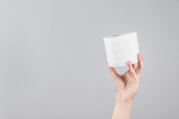 Hand with tissue paper on a gray background with copy space. Composition for advertising, article or banner
