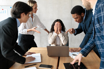 Displeased Business People Shouting At Unhappy Female Employee In Office - obrazy, fototapety, plakaty