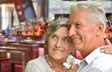  senior couple posing on blurred casino background