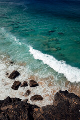 ola rompiendo en una playa de agua turquesa