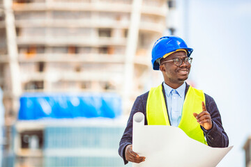 Smiling businessman with helmet on head standing in building in construction process and checking on works. Portrait of an architect holding his helmet.