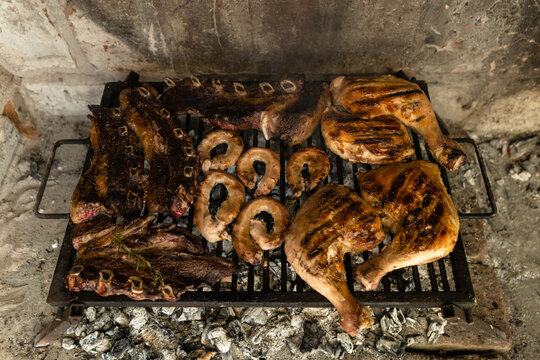 Top view of grilled argentinian asado. Short ribs, chicken quarters, and "chinchulines".
