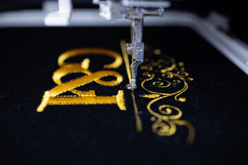 Machine embroidery on black velvet fabric with yellow thread. Embroidered ornaments and initials G...