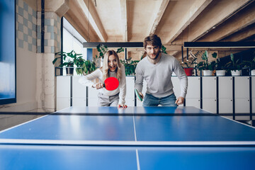 Young people, man and woman playing table tennis