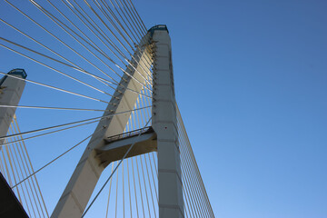 Bottom view of the cable-stayed bridge pylon and cable stays against the sky for the thematic banner