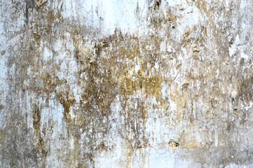 Concrete grey wall with ols cracked paint. Yellow, grey, white and beige colors. Abstract photo background. Urban style texture. Building exterior. Cement unique and attractive textures