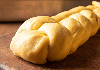 Fototapeta na wymiar Raw bread dough already in the shape of bread on wood, selective focus.
