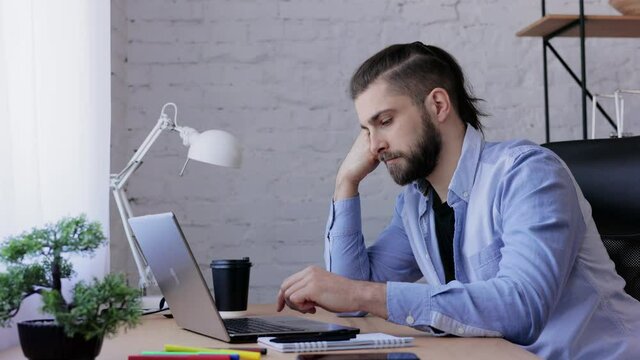 Depressed man overworked on laptop computer. Stressed worker recieved bad online news, failed exam results, had lack of creative ideas. Burnout syndrome, overworking, depression, apathy.