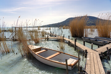 Fototapeta na wymiar Lake Balaton with a boat in the reed Badacsony hill background
