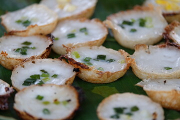 A traditional Thai dessert made from flour mixed with sugar and coconut milk placed on banana leaves.