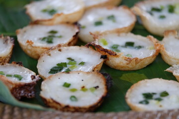 A traditional Thai dessert made from flour mixed with sugar and coconut milk placed on banana leaves.