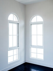Two half-moon windows white frame at white room corner with white backgrounds. Interior empty room wall and windows in a luxury house.