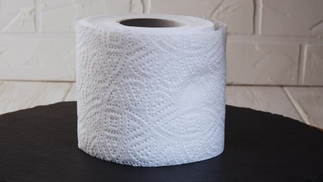 Toilet paper roll rotating on a black background. Presentation of toilet paper roll